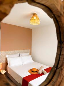 a bedroom with a bed with a hat on it at Ti Kaz des Roches in Saint-Louis
