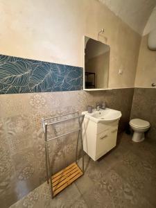 a bathroom with a sink and a toilet and a mirror at Handy Pergola in Brindisi +35 photos