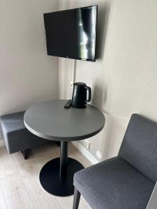 a table with a tv and a table with two chairs at Oslo Airport Apartments in Gardermoen