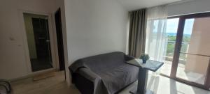 a living room with a couch and a large window at Vila Mihnevi in Chernomorets