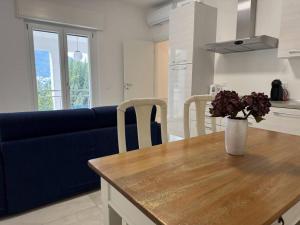 a living room with a blue couch and a table with flowers at Luxury Apartment LUNA in Moltrasio