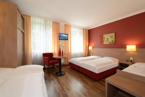 a hotel room with two beds and a table at Hotel Marienthal Garni in Hamburg