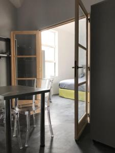 Zimmer mit einem Tisch, einem Bett und einem Spiegel in der Unterkunft Smart Living in Saint-Nazaire