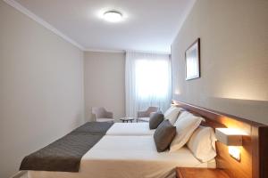 a hotel room with a large bed and a window at Hotel San Lorenzo in Santiago de Compostela