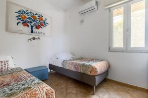 ein Schlafzimmer mit zwei Betten und einem Fenster in der Unterkunft Villa Bouganville con piscina by Wonderful Italy in Syrakus