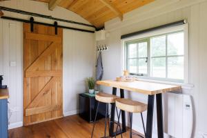 a kitchen with a table and a barn door at The Witterings Shepherds’ Hut in West Wittering