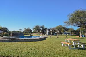 a park with a picnic table and a pool at Pioneer lodge in Lephalale