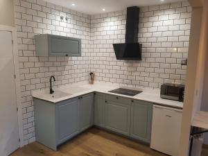 a kitchen with a sink and a microwave at Pensión CREDENCIAL in Sarria