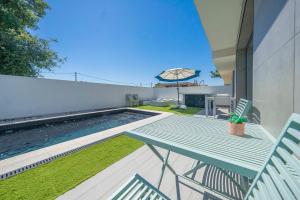 un tavolo blu e sedie accanto alla piscina di Black Pool House just 10 minutes away from the beach a Amora