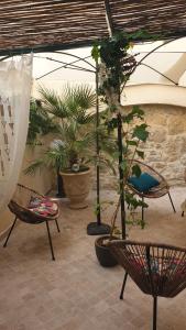 un patio avec des chaises et des plantes en pot dans l'établissement Le Clos du rouet, à Tarascon