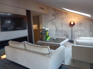 a living room with two couches and a tv at Miramare Suites in Sestri Levante