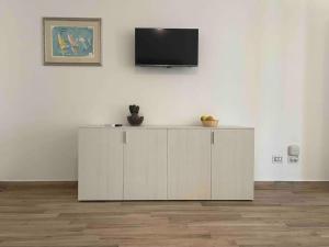 a white cabinet with a television on a wall at Appartamento Burantinu in Alghero