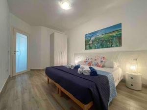 a bedroom with a large bed with a blue blanket at Appartamento Burantinu in Alghero +15 photos