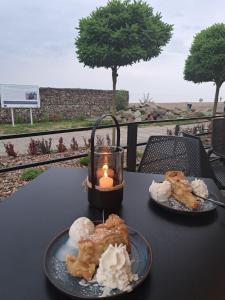 due piatti di cibo su un tavolo con una candela di Nadmorski dom przy plaży a Mechelinki