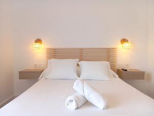 um quarto com uma grande cama branca e 2 almofadas em HOSTAL CASA EMILIO em Almería