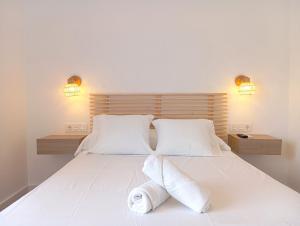 a bedroom with a large white bed with two pillows at HOSTAL CASA EMILIO in Almería