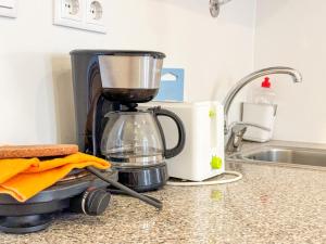 a coffee maker sitting on a counter next to a sink at Home Sonhos 64 in Lisbon