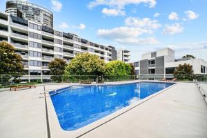 悉尼Relaxing 1BR w Pools & SPA, Gym in Olympic Park的建筑物前的一个空游泳池