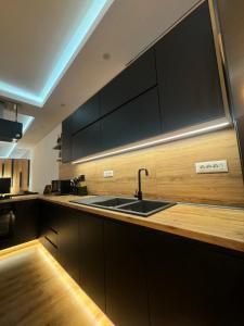a kitchen with a sink and wooden counter top at Luxury Central Baba Apartment in Shkodër