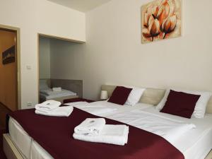 a bedroom with a large bed with towels on it at Hotel Crocus in Štrbské Pleso