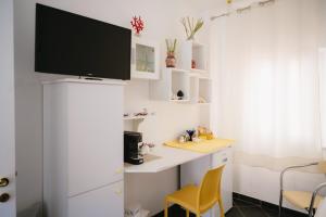 a room with a desk with a tv on a wall at Stop And Go in Scilla