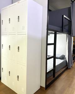 a bedroom with a bunk bed and a bunk bed ladder at Bed Space Hostel @Khaosan in Bangkok