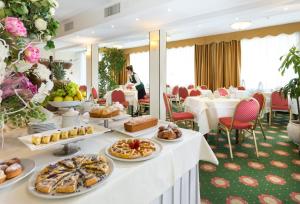 a table with food on it in a restaurant at Hotel De Londres in Rimini