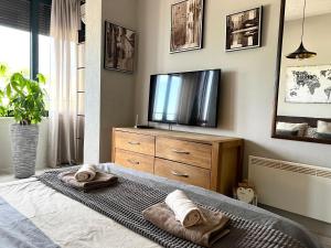a bedroom with a television and towels on a bed at Panama apartment in Ulcinj