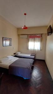 ブエノスアイレスにあるHotel Litoral CERCA DE MOVISTAR ARENAのベッド2台と窓のある寝室