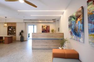 an office lobby with a staircase and paintings on the wall at Falena Luxury Rooms in Kalyves Poligirou