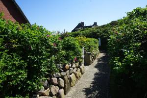 einen Garten mit Blumen und einer Steinmauer in der Unterkunft Ferienwohnung Dikstig Rechts in Kampen