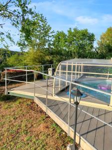 a deck with a swimming pool and a metal railing at Bungalow de 2 chambres avec piscine privee jardin clos et wifi a Saint Chamassy a 3 km de la plage in Saint-Chamassy