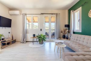 a living room with a couch and a table at Aegean Sunset Luxury Penthouse in Lygaria