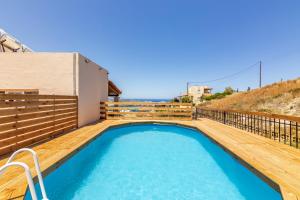 a swimming pool on the deck of a house at Aegean Sunset Luxury Penthouse in Lygaria