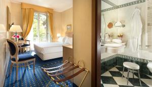 a hotel room with a bed and a bathroom at Hotel De Londres in Rimini