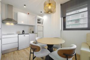 a kitchen and dining room with a table and chairs at Arena 20 Suites in Valencia