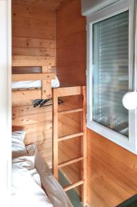een slaapkamer met een stapelbed en een raam bij Chalet de 2 chambres avec piscine partagee jardin amenage et wifi a Saint Jean du Gard in Saint-Jean-du-Gard