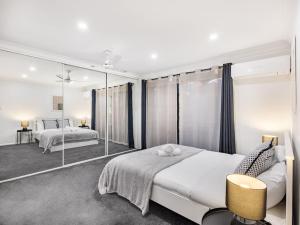 a bedroom with two beds and a large mirror at Private and Spacious 4BR Home with Parkview 5mins to Mall in Doolandella