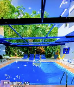 una gran piscina con sillas azules y un tobogán en The Blue Eco Lodge en Valladolid