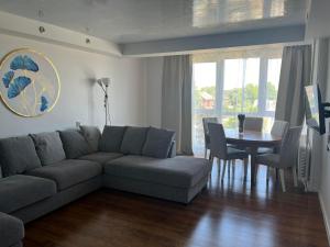 a living room with a couch and a table at Apartmentai Baltoji Ramune in Palanga