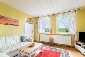 a living room with a white couch and a table at Auszeit Il am Deich auf Nordstrand in Nordstrand
