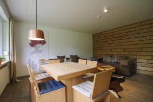 姆根布朗Fewo "am Mühlenbach" im Haus Hohfels, 2 Schlafzimmer, Todtnau-Muggenbrunn, Hochschwarzwald的配有木桌椅的餐厅
