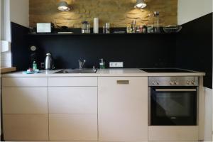 姆根布朗Fewo "am Mühlenbach" im Haus Hohfels, 2 Schlafzimmer, Todtnau-Muggenbrunn, Hochschwarzwald的厨房配有白色橱柜、水槽和炉灶 更多16张照片