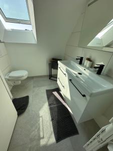 a bathroom with a white sink and a toilet at Les mouettes, SPA privé, 600m de la plage, Formule tout inclus in Erdeven +11 photos