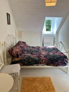 a bed sitting in a room with a window at repos en forêt in Huelgoat