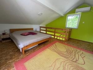 ein Schlafzimmer mit einem Bett und einer grünen Wand in der Unterkunft Hotri House On The River Island in Ripač