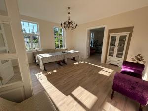 a living room with a table and purple chairs at Peaceful summer house - Sunshine in Jūrmala