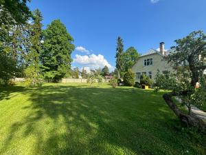 a large green yard with a house and trees at Peaceful summer house - Sunshine in Jūrmala