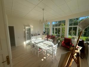 a dining room and living room with a table and chairs at Peaceful summer house - Sunshine in Jūrmala