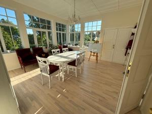 a dining room with a white table and chairs at Peaceful summer house - Sunshine in Jūrmala